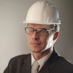 Confident engineer in suit and hard hat, ready for construction project.